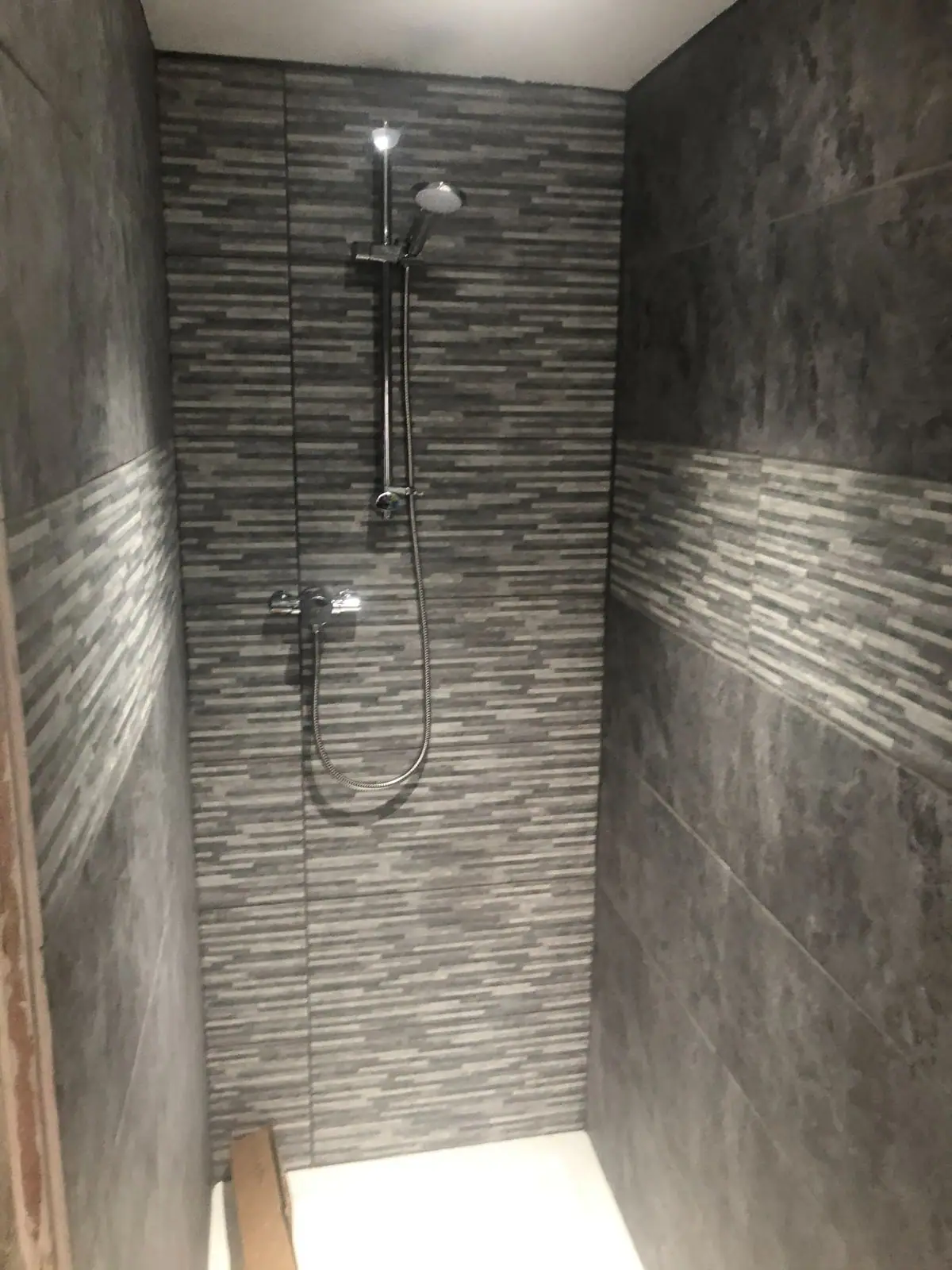Walk-in shower with mosaic tile strip