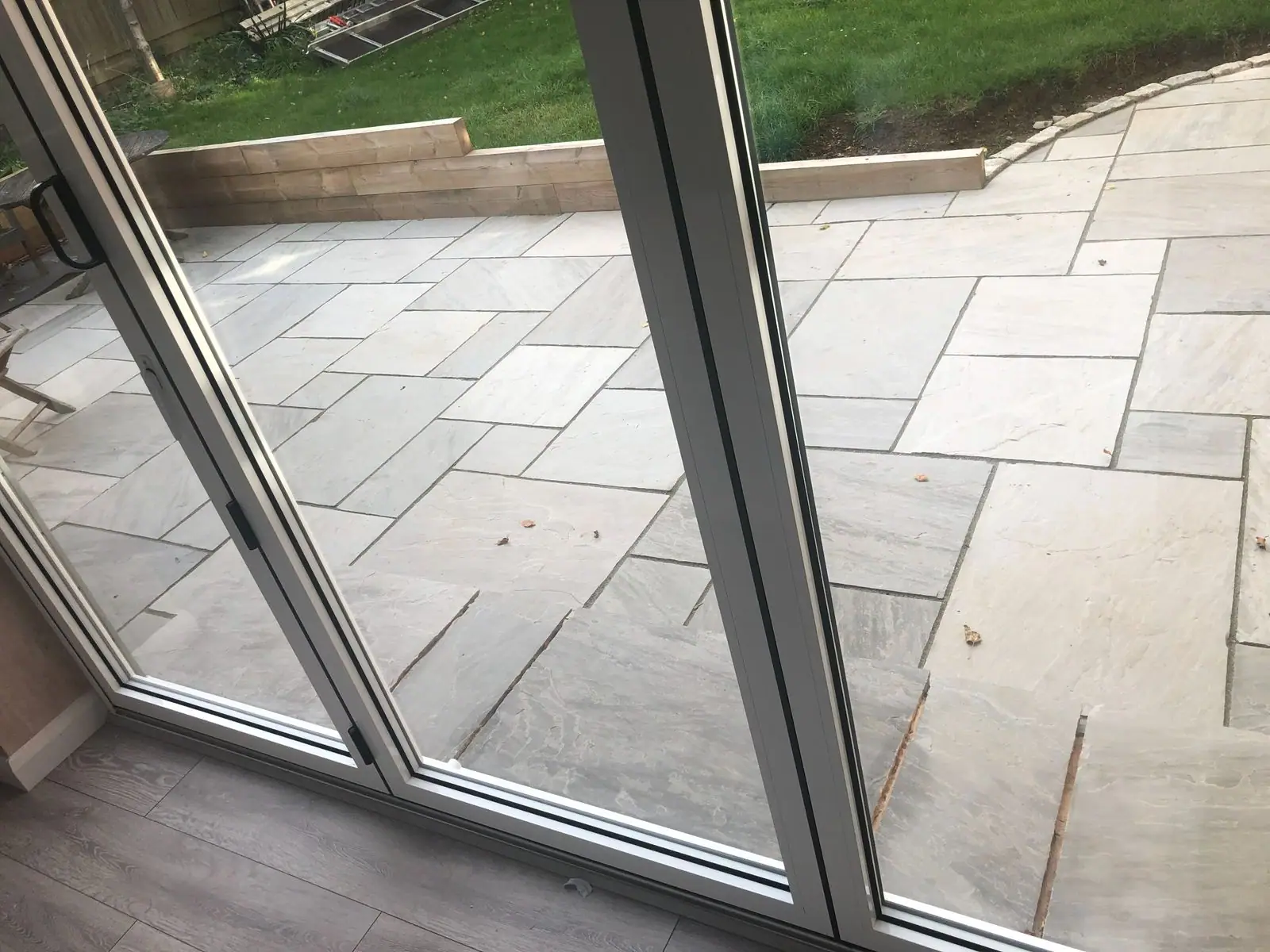 Indian sandstone patio seen through new bifold doors