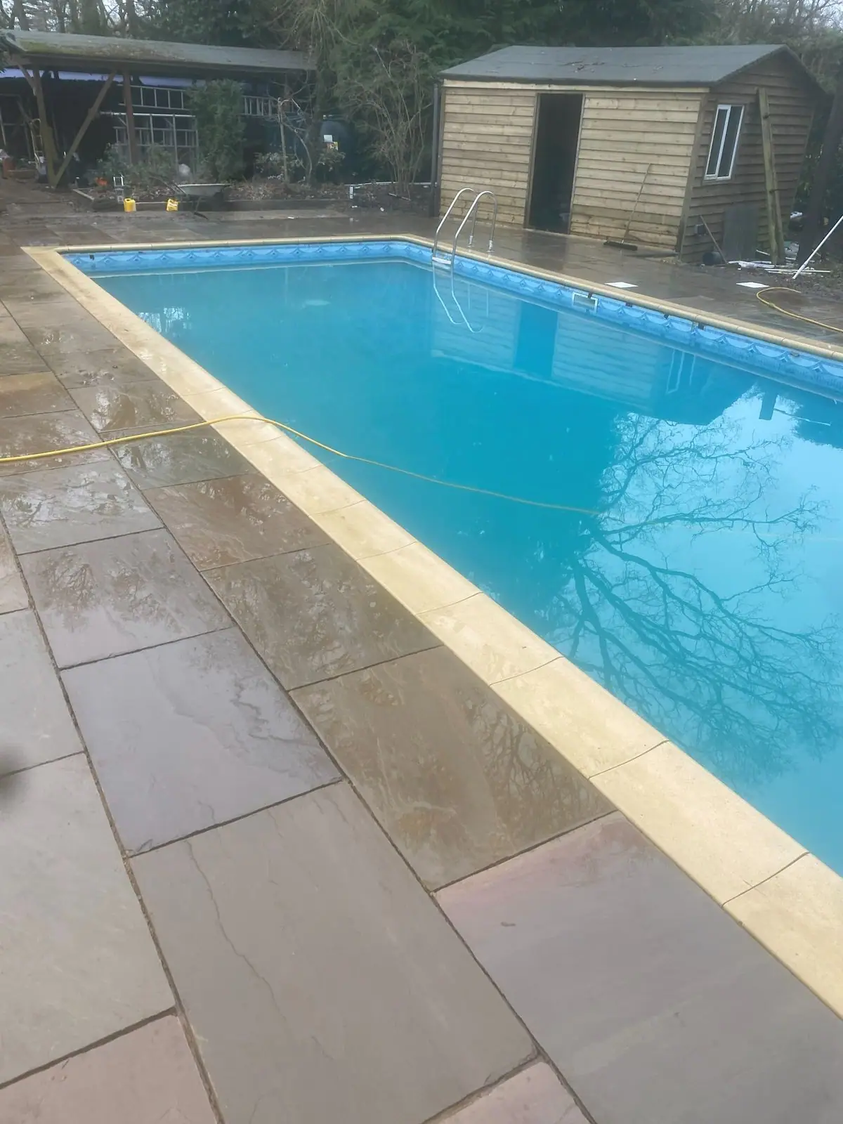 Length of the pool with new sandstone paving