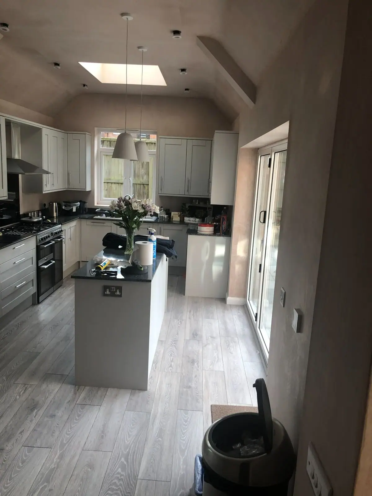 Shaker-style kitchen with island under a vaulted ceiling with roof lights