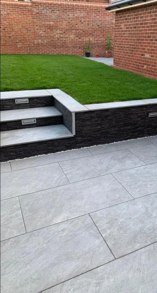 Steps up from the porcelain patio to the lawn