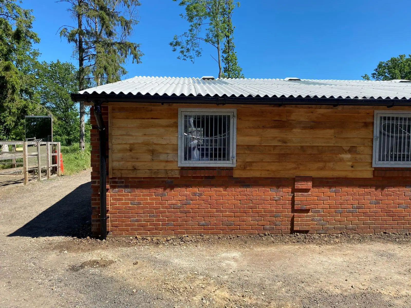 Finished stable block with brick base, timber cladding and corrugated roof