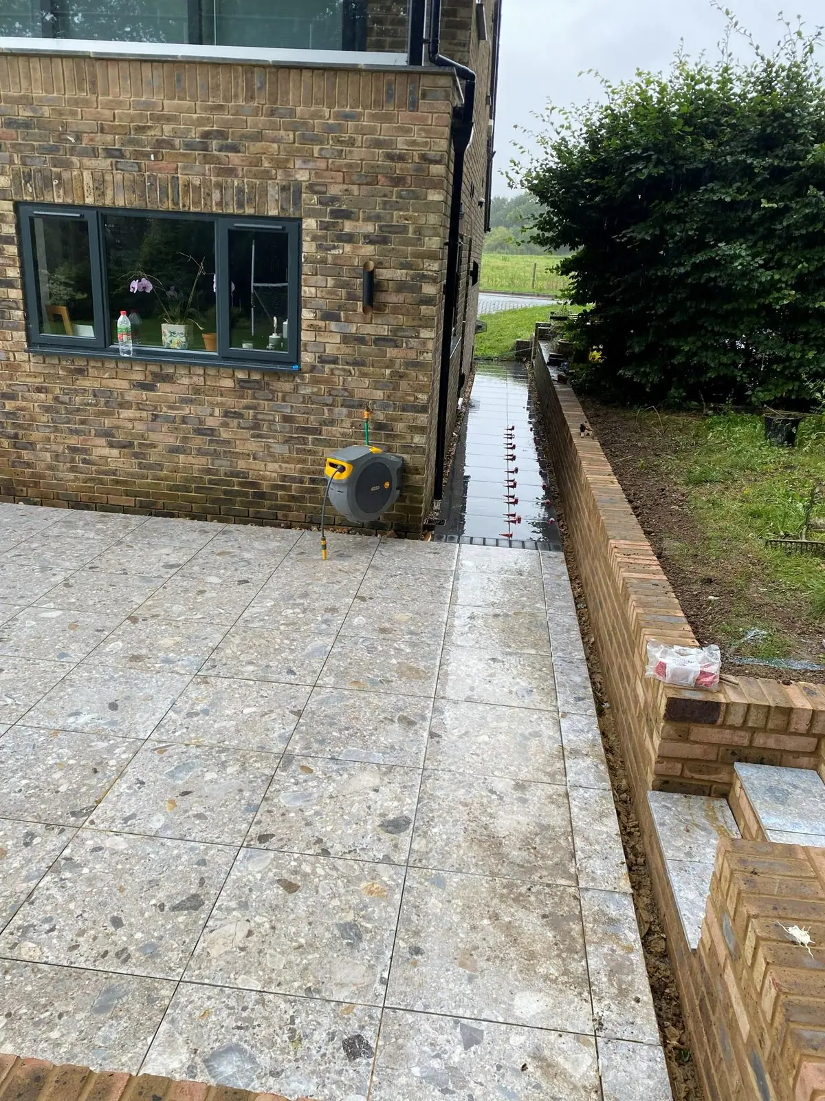Porcelain terrace and brick edging along the house